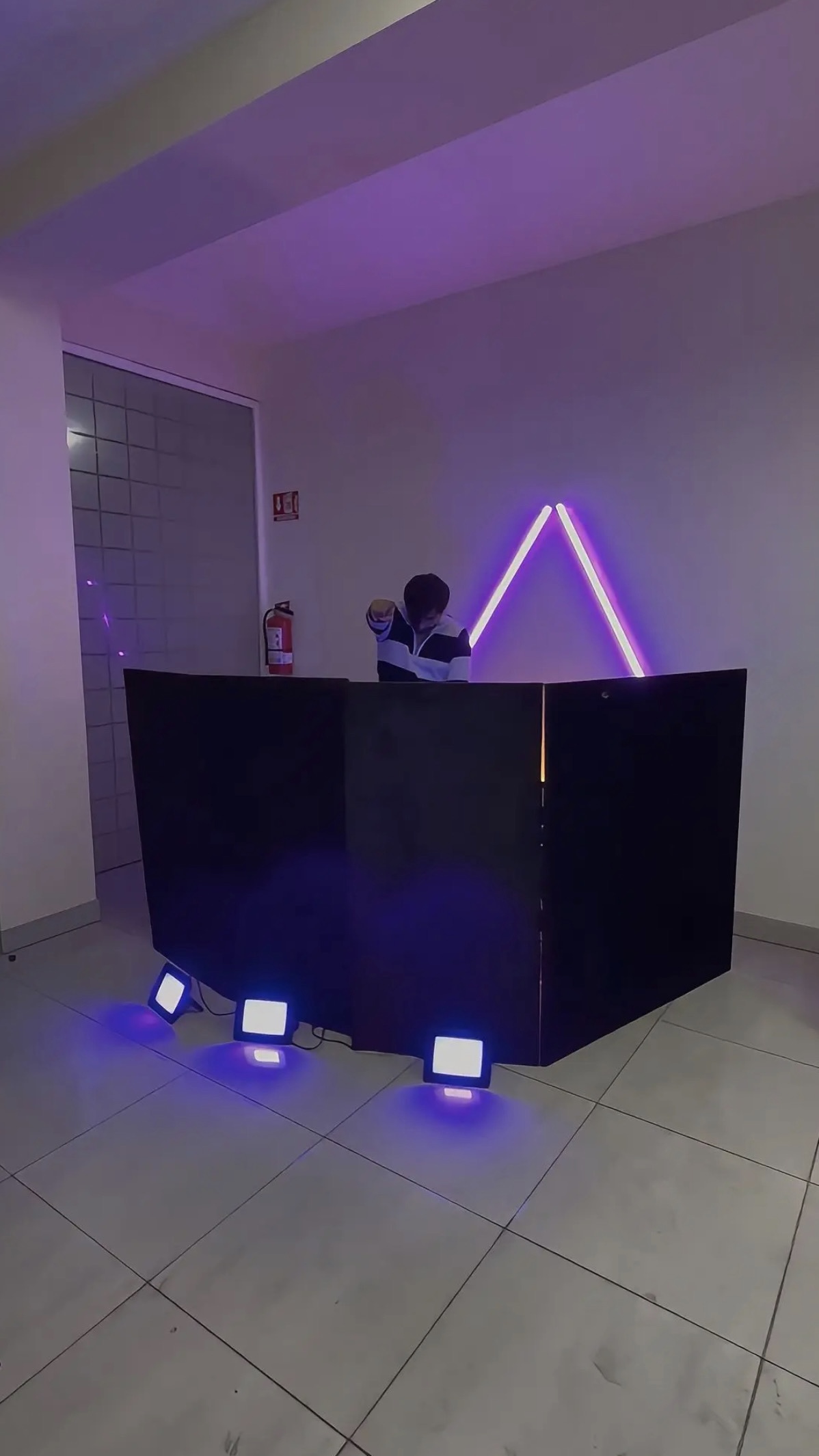 Cabina de DJ con iluminación LED morada y triángulo Lemans